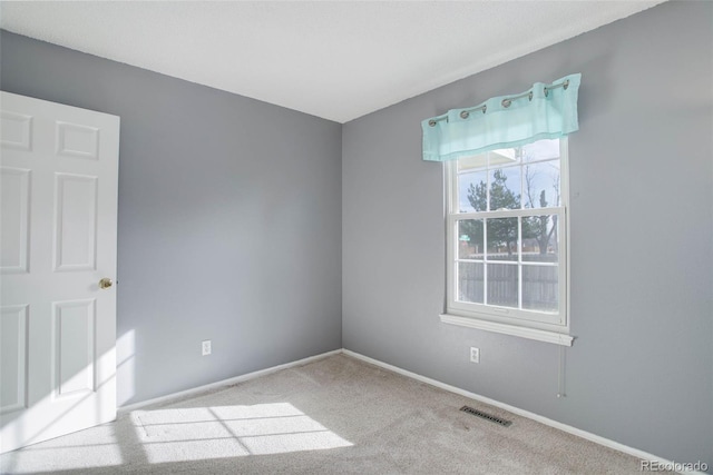 empty room with visible vents, baseboards, and carpet