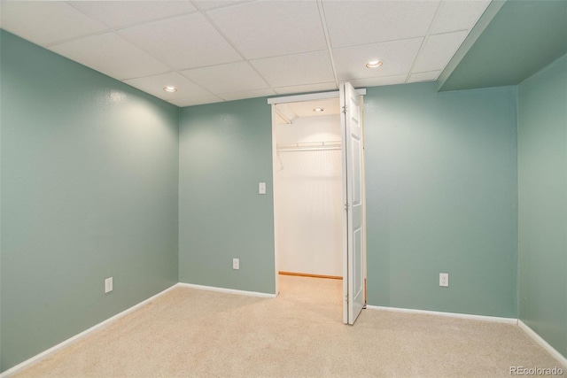 carpeted empty room with recessed lighting, baseboards, and a drop ceiling