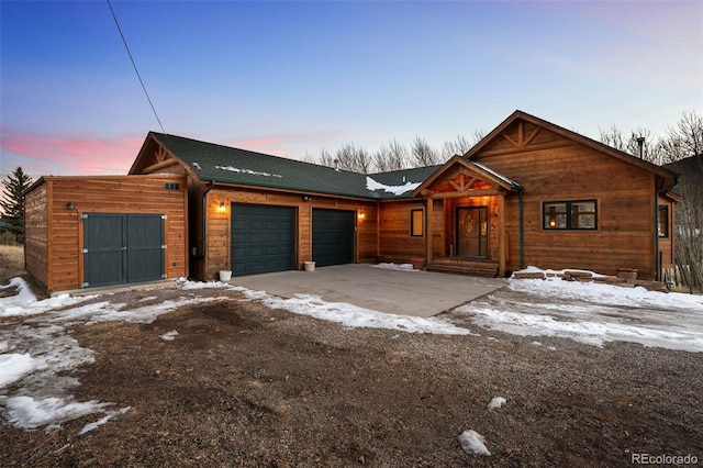 rustic home with a garage and driveway