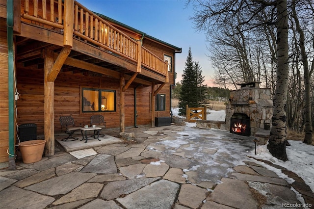 exterior space with an outdoor stone fireplace and a patio area