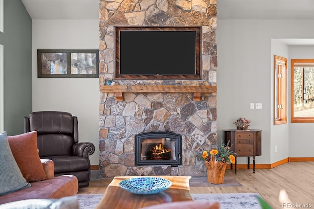 living room featuring a fireplace, wood finished floors, and baseboards