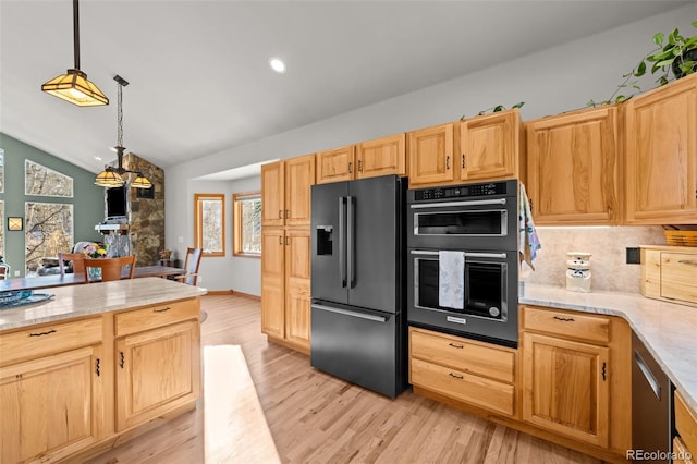 kitchen featuring dobule oven black, lofted ceiling, high quality fridge, hanging light fixtures, and light wood-style floors