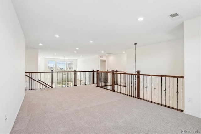 carpeted spare room featuring recessed lighting, visible vents, and baseboards