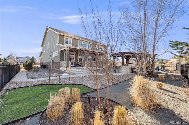 back of property with a yard, a fenced backyard, a pergola, and a patio area