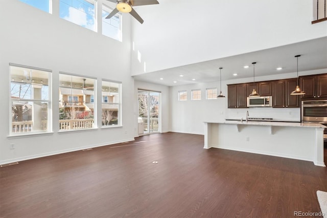 kitchen with dark wood-type flooring, appliances with stainless steel finishes, a healthy amount of sunlight, and light countertops