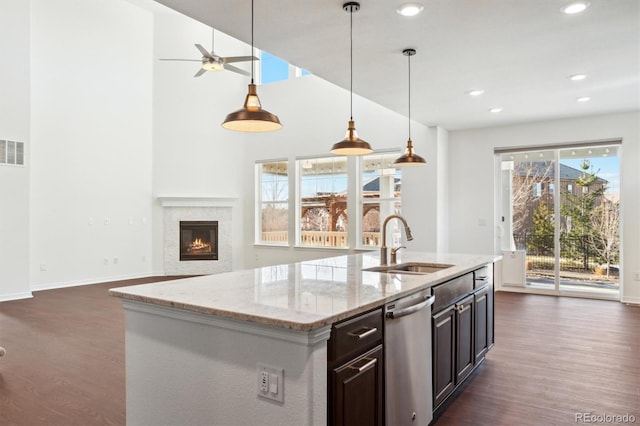 kitchen with dark wood-style flooring, dishwasher, a glass covered fireplace, and a sink