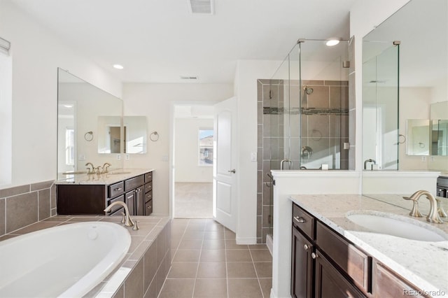 bathroom featuring a bath, visible vents, a stall shower, and a sink