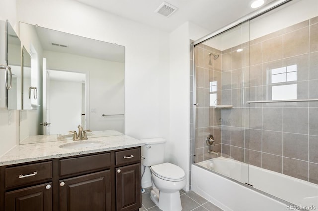 full bathroom with tile patterned floors, visible vents, toilet, shower / bath combination with glass door, and vanity