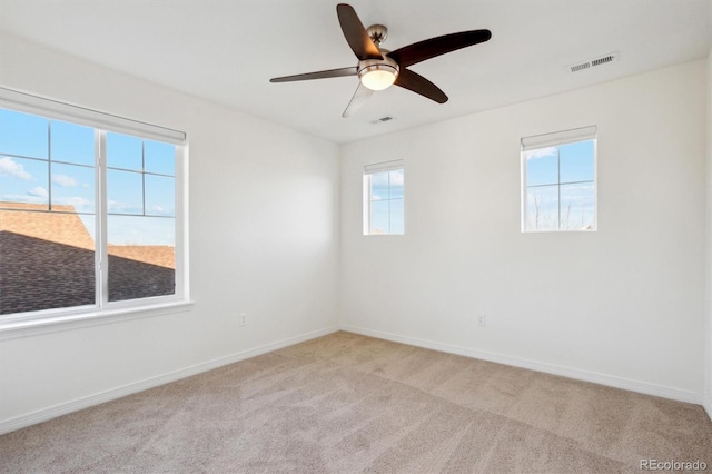 unfurnished room featuring visible vents, baseboards, and light colored carpet