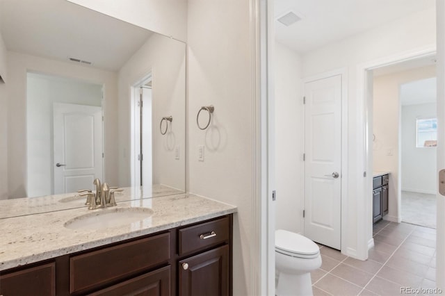 bathroom with tile patterned flooring, toilet, vanity, and visible vents