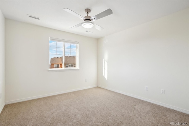 carpeted empty room featuring visible vents, baseboards, and ceiling fan