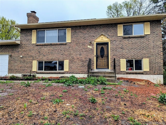 bi-level home with a chimney and brick siding