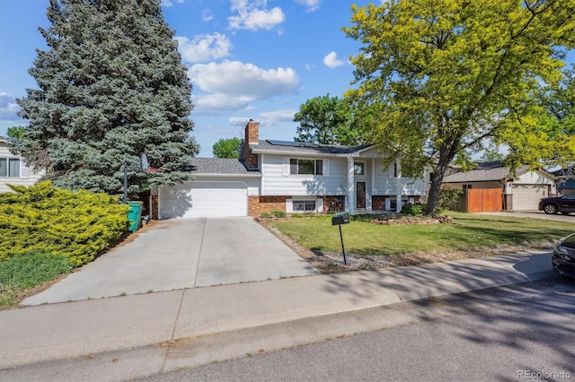 848 S 13th Ave, Brighton, CO 80601 - split foyer home featuring a front yard, brick siding, solar panels, driveway, and a garage