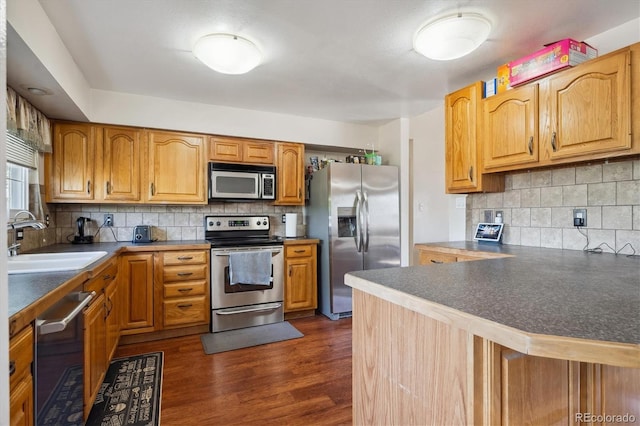 848 S 13th Ave, Brighton, CO 80601 - kitchen with appliances with stainless steel finishes, a sink, decorative backsplash, and dark wood-type flooring