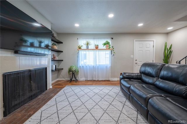 living area with baseboards, wood finished floors, and recessed lighting