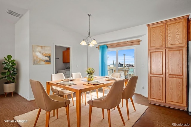 51 W 6th Pl, Byers, CO 80103 - dining area with dark wood finished floors, a chandelier, and vaulted ceiling