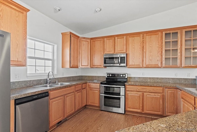 51 W 6th Pl, Byers, CO 80103 - kitchen featuring stainless steel appliances, vaulted ceiling, wood finished floors, and glass insert cabinets