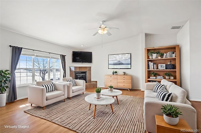 51 W 6th Pl, Byers, CO 80103 - living room with a ceiling fan, light wood-style flooring, and a tile fireplace