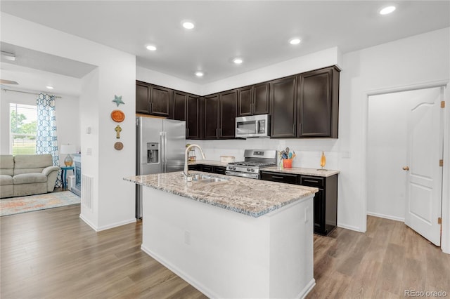 kitchen featuring light hardwood / wood-style floors, stainless steel appliances, a kitchen island with sink, and sink