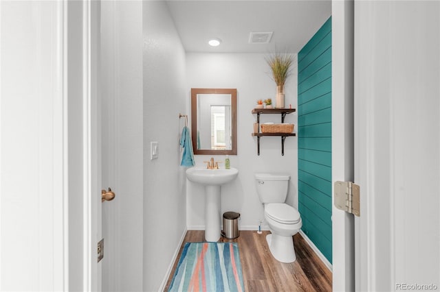 bathroom featuring wood-type flooring and toilet