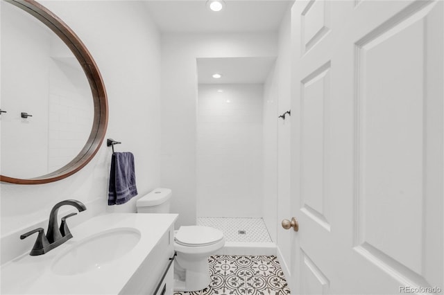 bathroom featuring tiled shower, tile patterned floors, toilet, and vanity