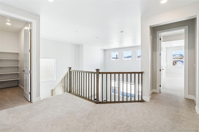 hall with light colored carpet