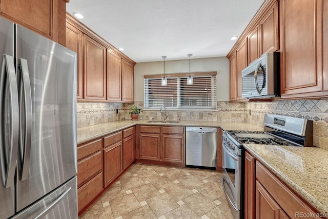 kitchen featuring a sink, decorative backsplash, appliances with stainless steel finishes, and brown cabinetry