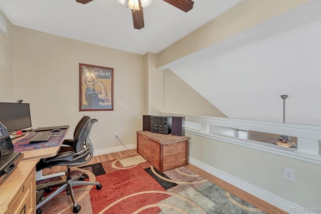 home office with a ceiling fan, lofted ceiling, baseboards, and light wood-type flooring