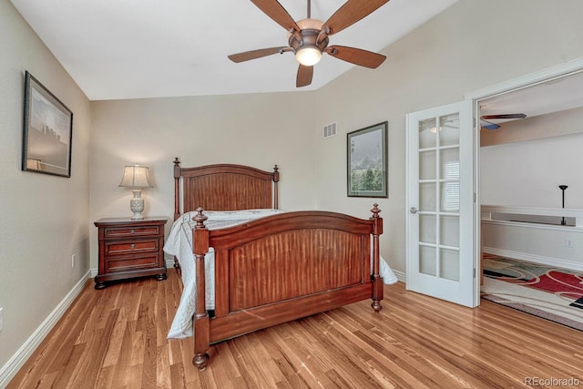 bedroom featuring a ceiling fan, wood finished floors, visible vents, baseboards, and french doors