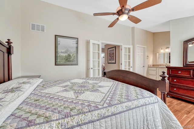 bedroom featuring visible vents, a ceiling fan, wood finished floors, connected bathroom, and french doors