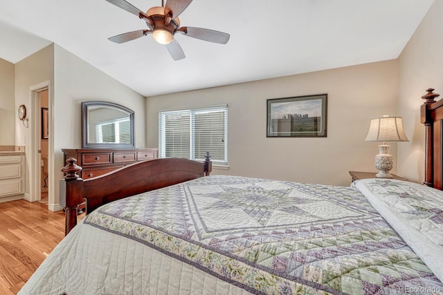 bedroom with ceiling fan, lofted ceiling, light wood-style flooring, and ensuite bathroom