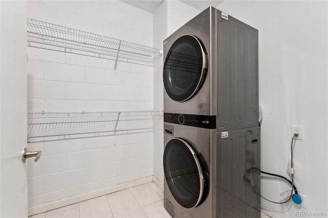 washroom with light tile patterned floors and stacked washer and dryer