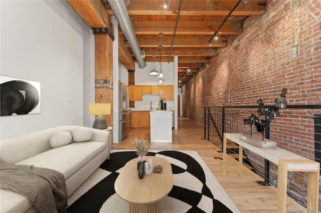 living room featuring brick wall, wood ceiling, light hardwood / wood-style floors, rail lighting, and beam ceiling