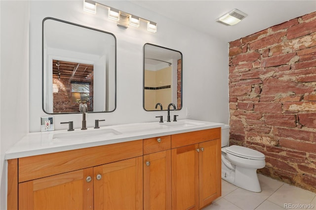 bathroom featuring toilet, tile patterned flooring, brick wall, and vanity