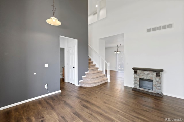4807 S Killarney Ct, Aurora, CO 80015 - unfurnished living room with a high ceiling, wood finished floors, stairway, a chandelier, and a fireplace