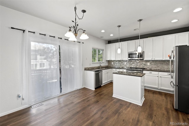 4807 S Killarney Ct, Aurora, CO 80015 - kitchen featuring appliances with stainless steel finishes, dark countertops, recessed lighting, dark wood-type flooring, and decorative backsplash