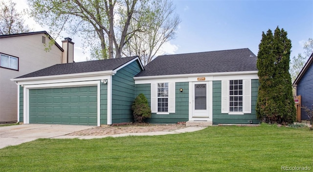 view of front of house with a front yard, driveway, a chimney, and a garage