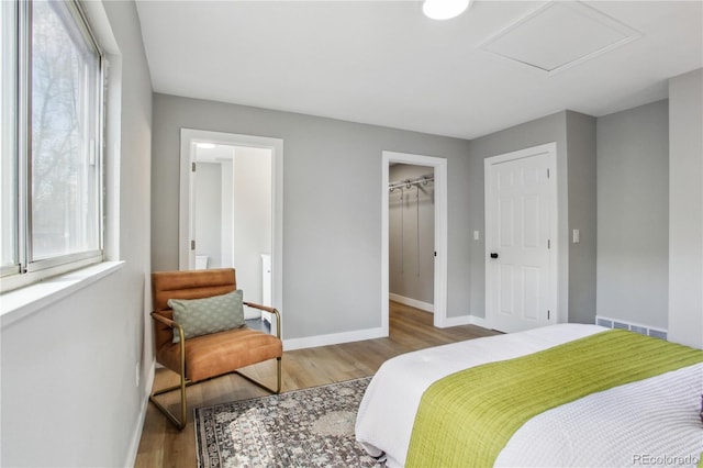 bedroom with baseboards, wood finished floors, and a closet