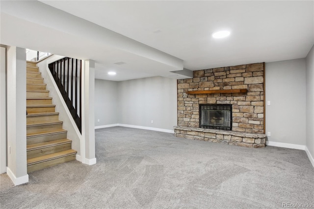 unfurnished living room with carpet flooring, a fireplace, and baseboards