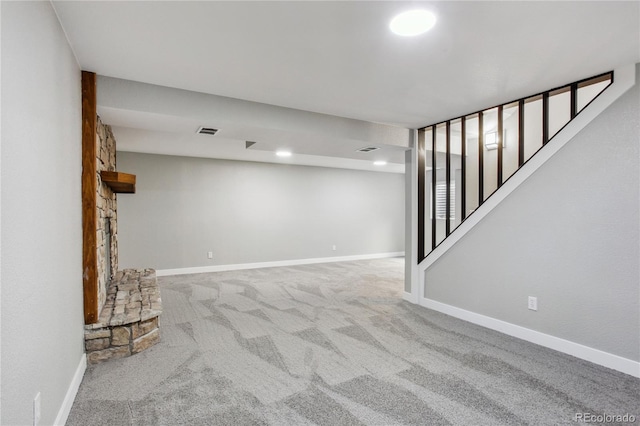 finished basement featuring baseboards, stairway, visible vents, and carpet