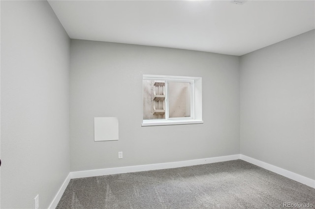spare room featuring carpet flooring and baseboards