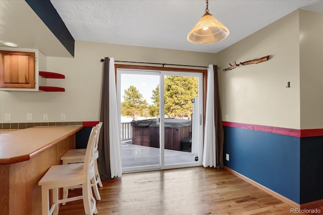 doorway featuring light hardwood / wood-style floors and a textured ceiling