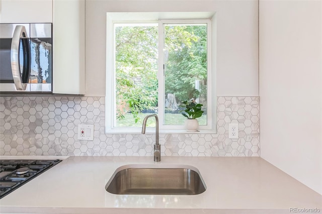 710 Raleigh St, Denver, CO 80204 - kitchen featuring stainless steel microwave, light countertops, and tasteful backsplash