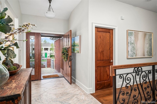 entryway with baseboards and marble finish floor