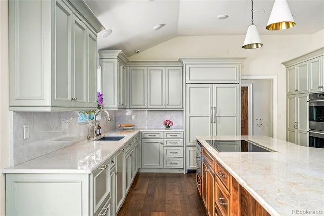 kitchen featuring light stone counters, a sink, black electric cooktop, and vaulted ceiling
