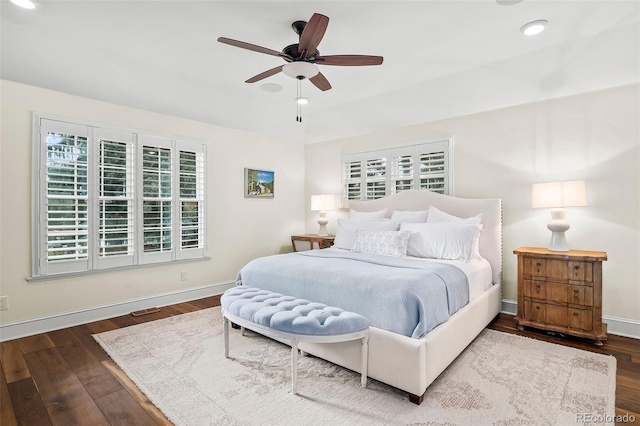 bedroom featuring baseboards, recessed lighting, dark wood-style floors, and multiple windows