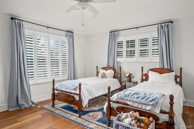 bedroom featuring baseboards, ceiling fan, and wood finished floors
