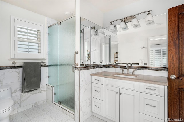 bathroom featuring vanity, tile walls, a shower stall, and toilet