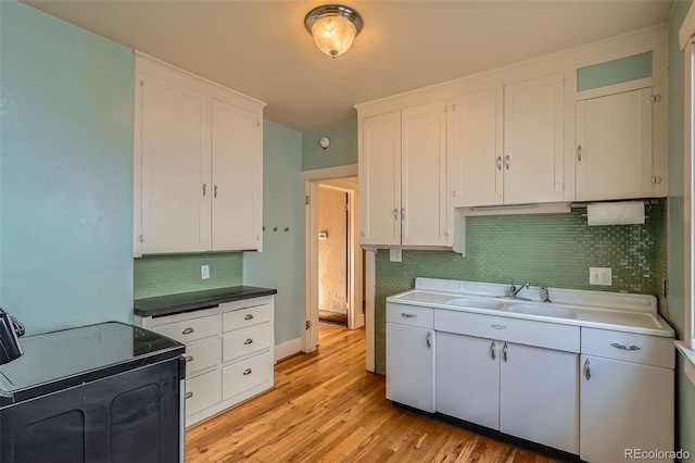 kitchen featuring electric range oven, light hardwood / wood-style floors, and white cabinets