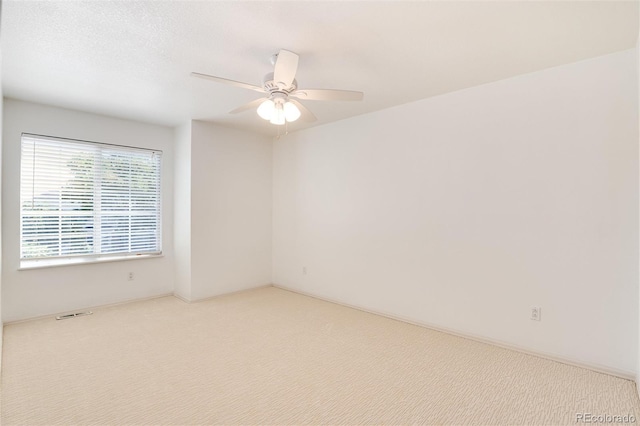 carpeted empty room featuring ceiling fan